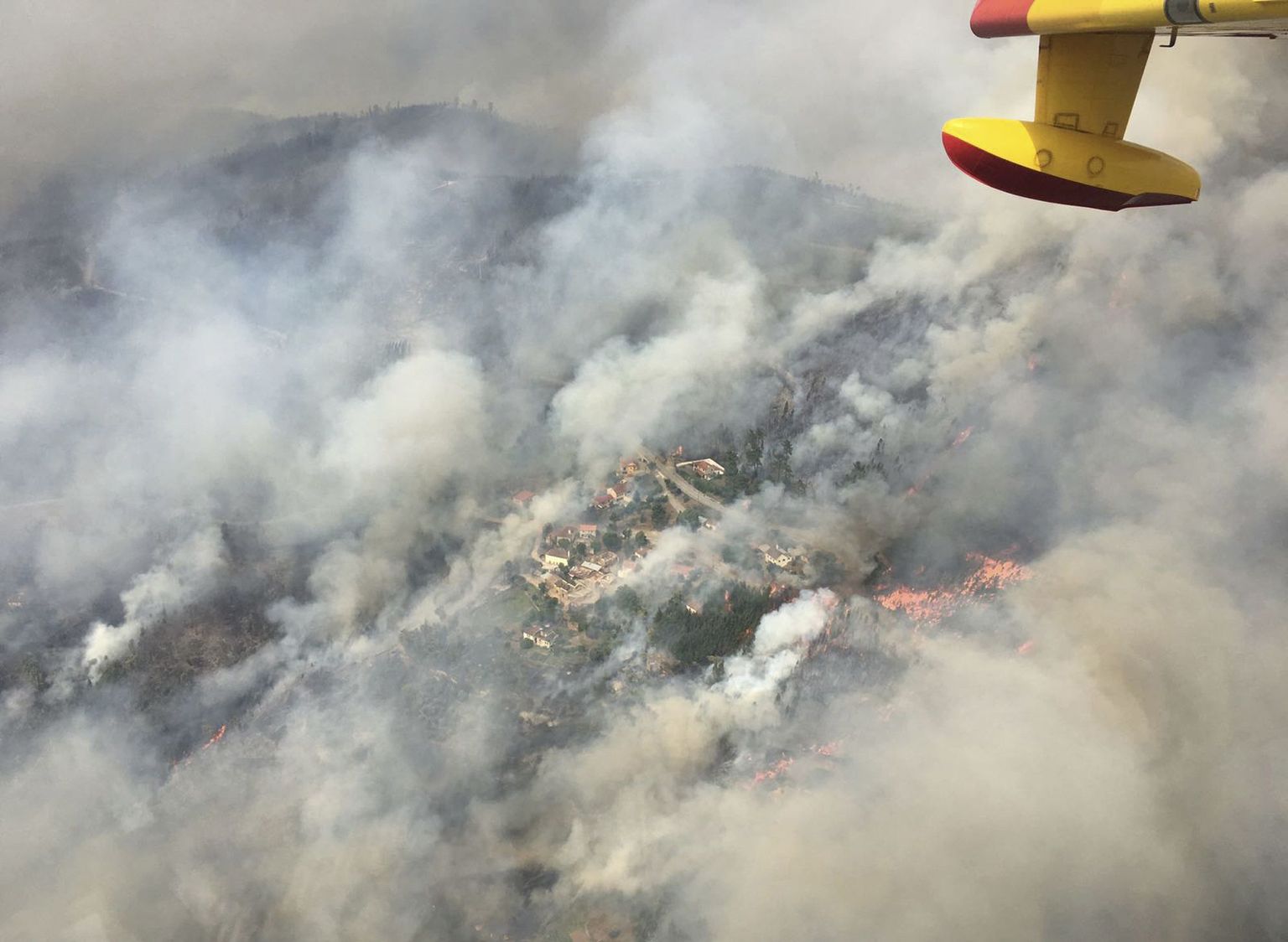 Portugalile appi tõtanud naaberriigi Hispaania tuletõrje lennukist tehtud fotol on näha leekidest ümbritsetud Pedrógão Grande linnake.