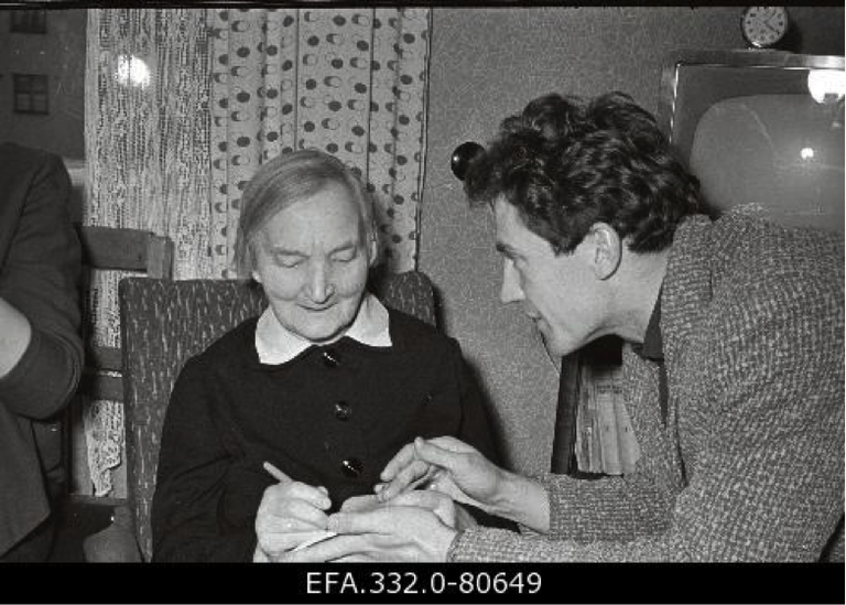 Kirjanik Eduard Vilde abikaasa Linda Vilde annab autogrammi Eesti NSV Riikliku Vene Draamateatri näitlejale Foma Voronetskile.