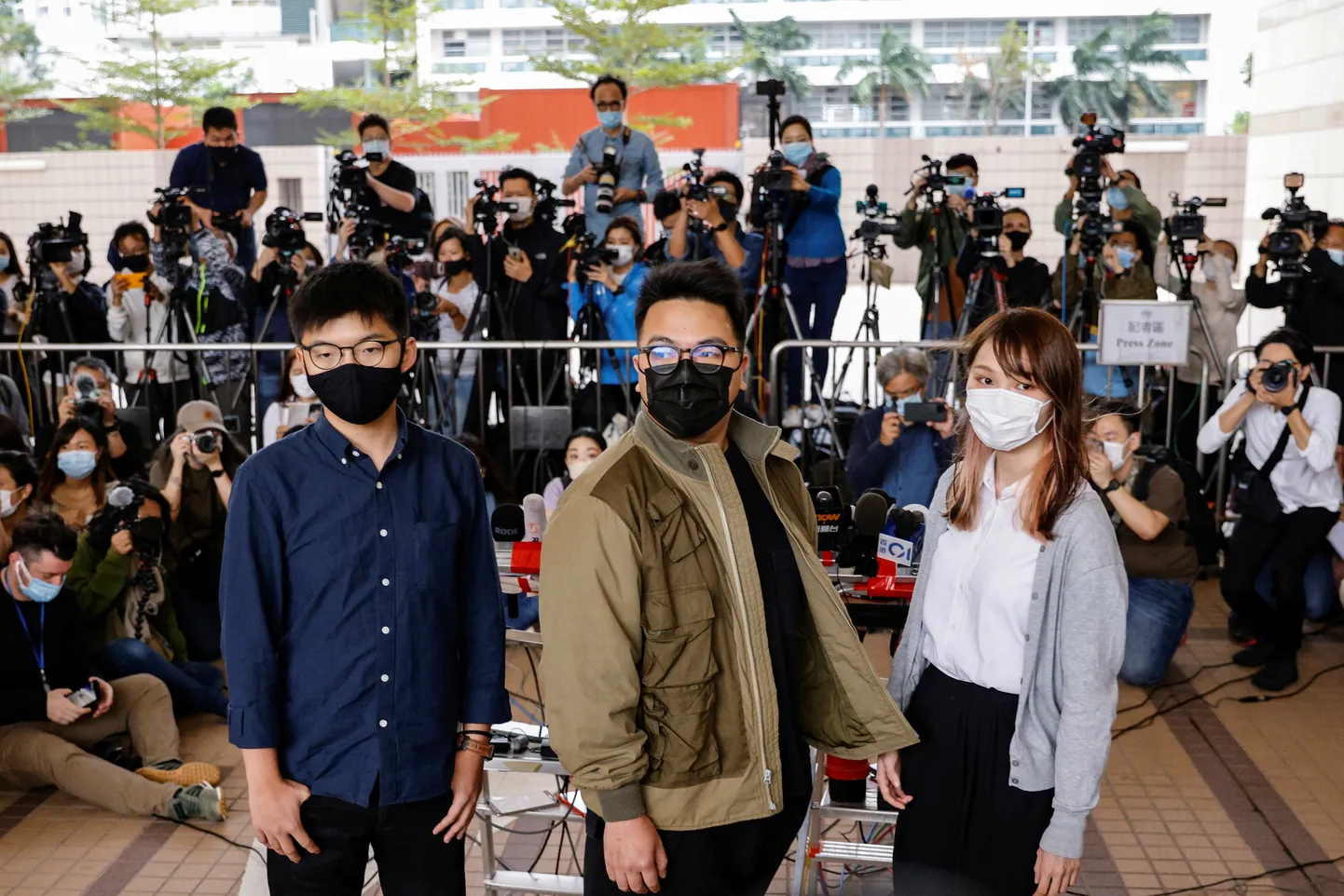 Hongkongi demokraatiaaktivistid Ivan Lam, Joshua Wong ja Agnes Chow kohtuhoone ees.
