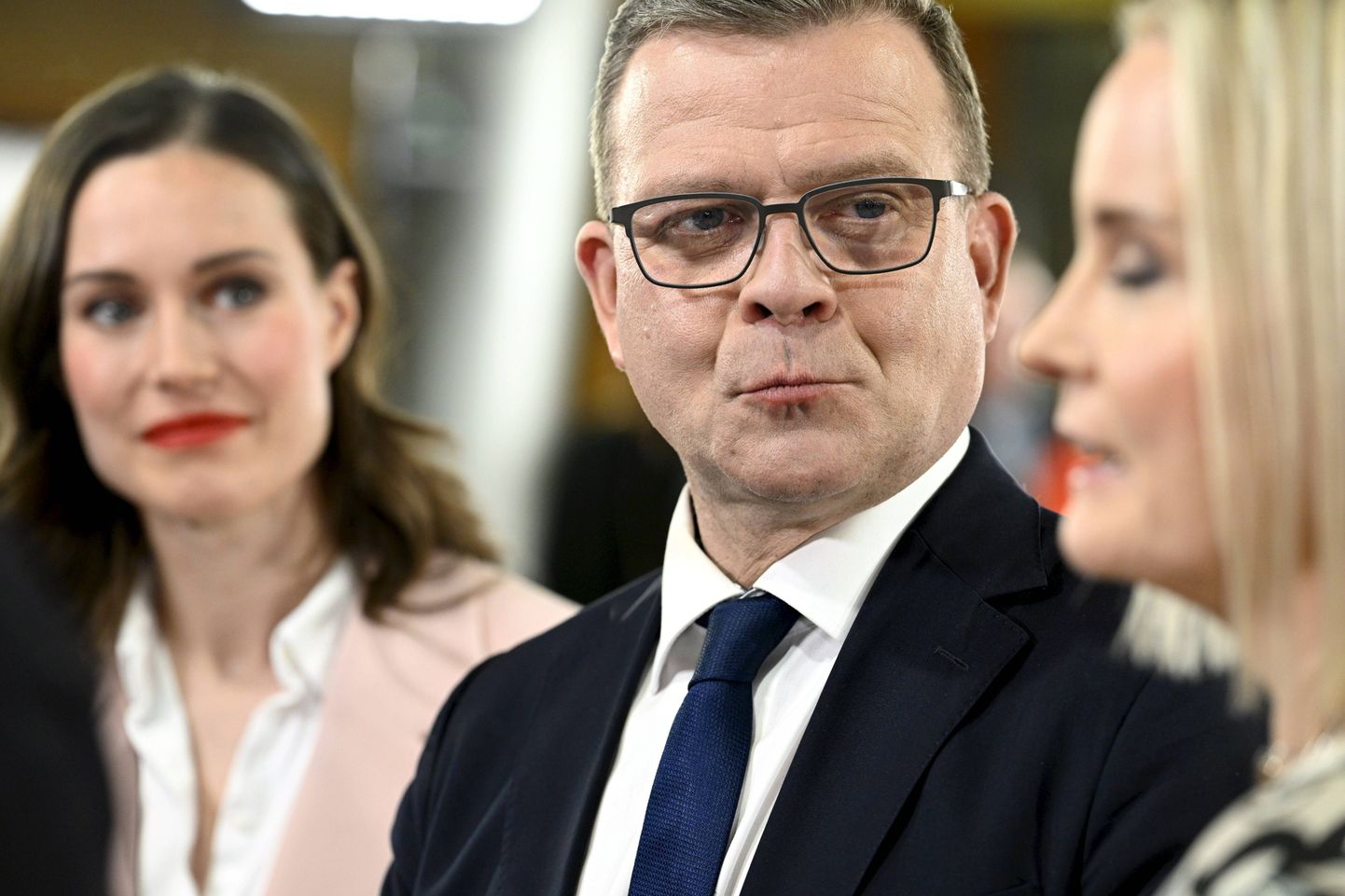 Koonderakonna esimees Petteri Orpo sotside liidri Sanna Marini ja Põlissoomlaste juhi Riikka Purra vahel valimisõhtul ajakirjanike ees.
