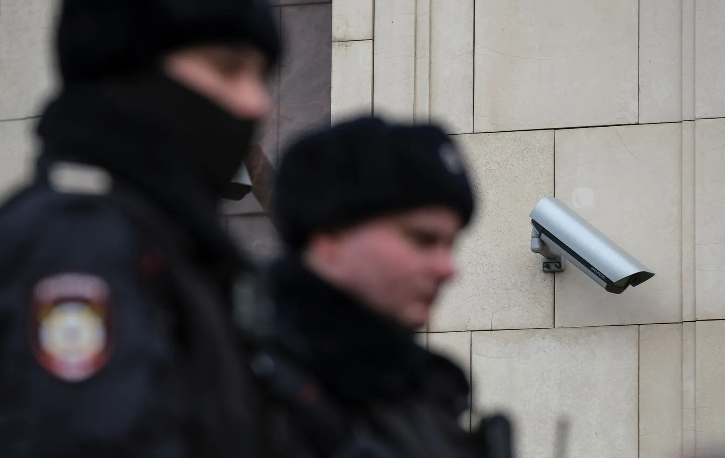 Российские полицейские на фоне камеры видеонаблюдения, установленной на одном из зданий в центре Москвы.