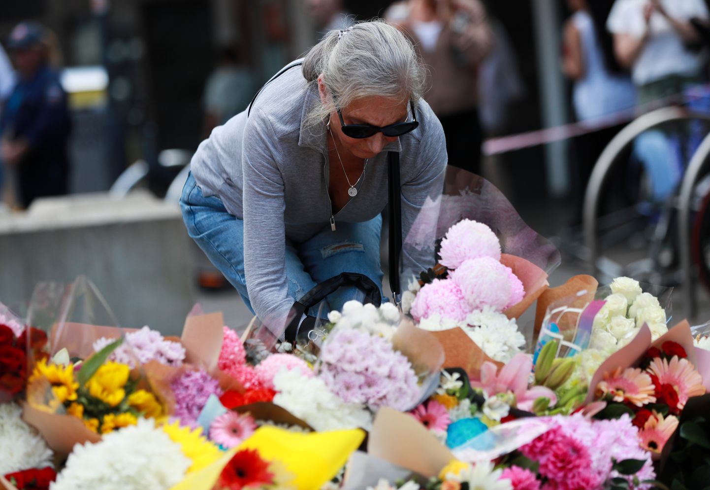 Inimesed viivad kaubamaja juurde lilli mälestamaks laupäevast tragöödiat.