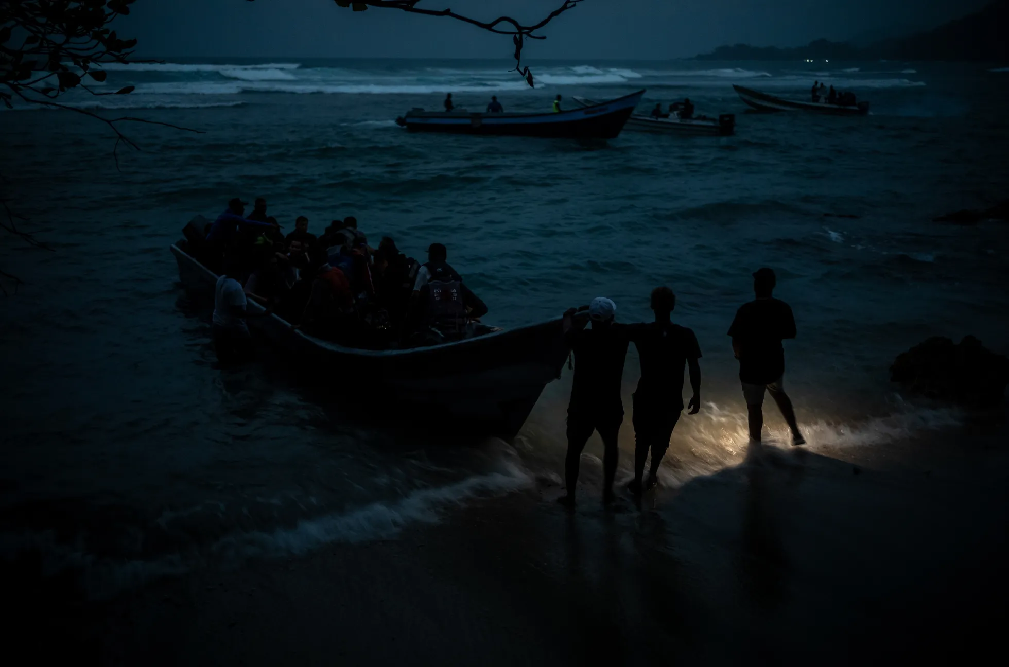 Rühm Afganistani, Hiina, Venezuela ja Ecuadori migrante sumab läbi vee paadi suunas, mis suundub Dariéni kuru poole. Paljud afgaanid polnud kunagi varem ookeani näinud. Capurganá, Colombia. Lõuna-Ameerika, pikaajalised fotolood.