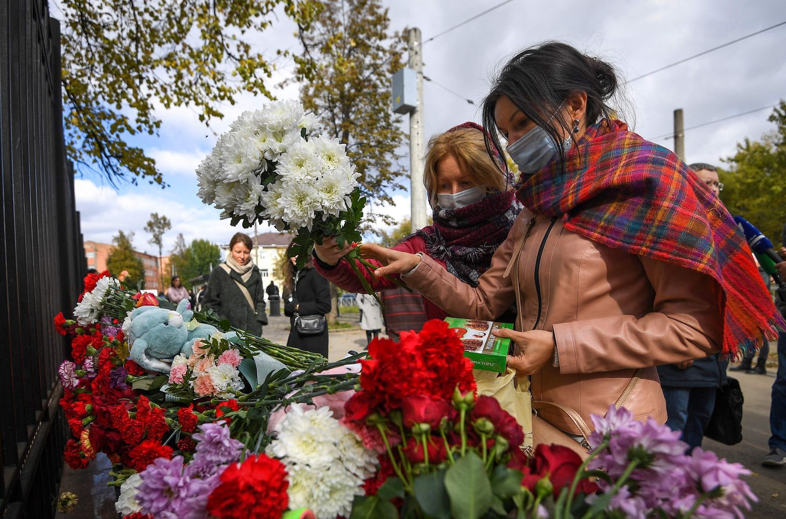 Студенты возлагают цветы к импровизированному мемориалу возле университетского городка в Перми, 21 сентября 2021.