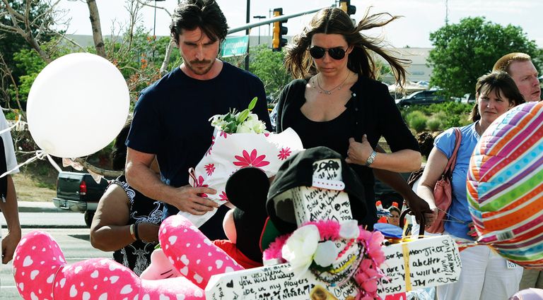 Актер Кристиан Бейл с супругой Сиби возлагает цветы возле кинотеатра в Колорадо, где была стрельба.