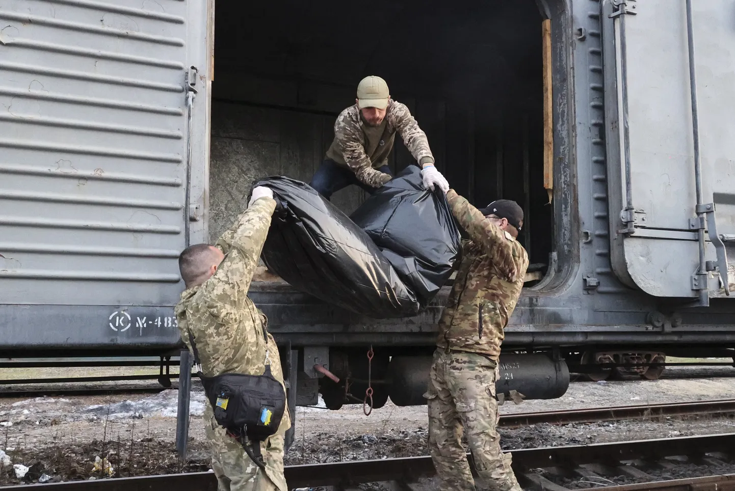 Sinikhas ciems Ukrainā 2023. gada 8. aprīlis. Refrižeratorvagonā tiek ievietotas Krievijas karavīra mirstīgās atliekas, kas tika atrastas pēc tam, kad ciemu savā kontrolē atkal pārņēma Ukrainas bruņotie spēki.