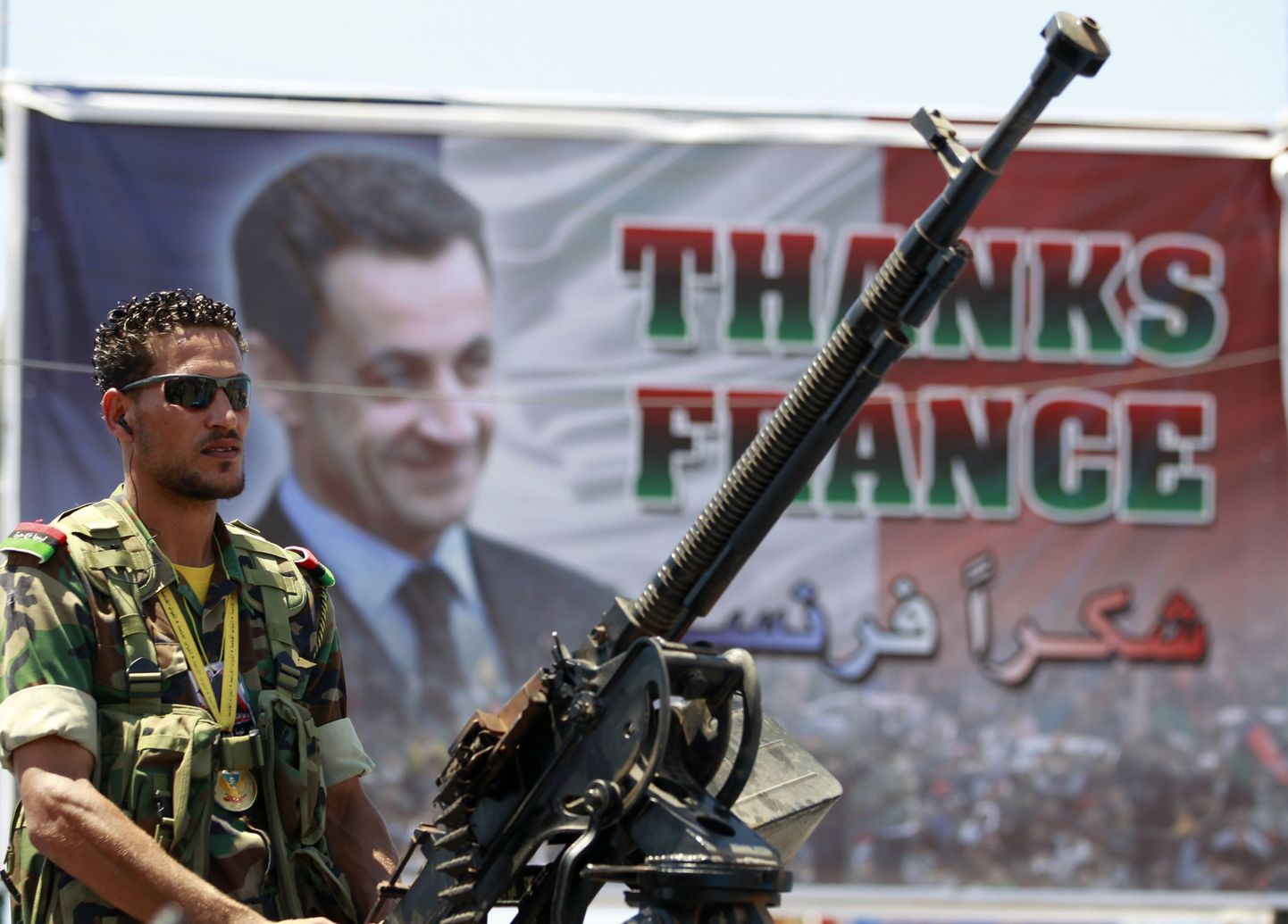 Liibüa mässuliste võitleja Prantsusmaad ja selle presidenti Nicolas Sarkozyd tänava plakati ees.