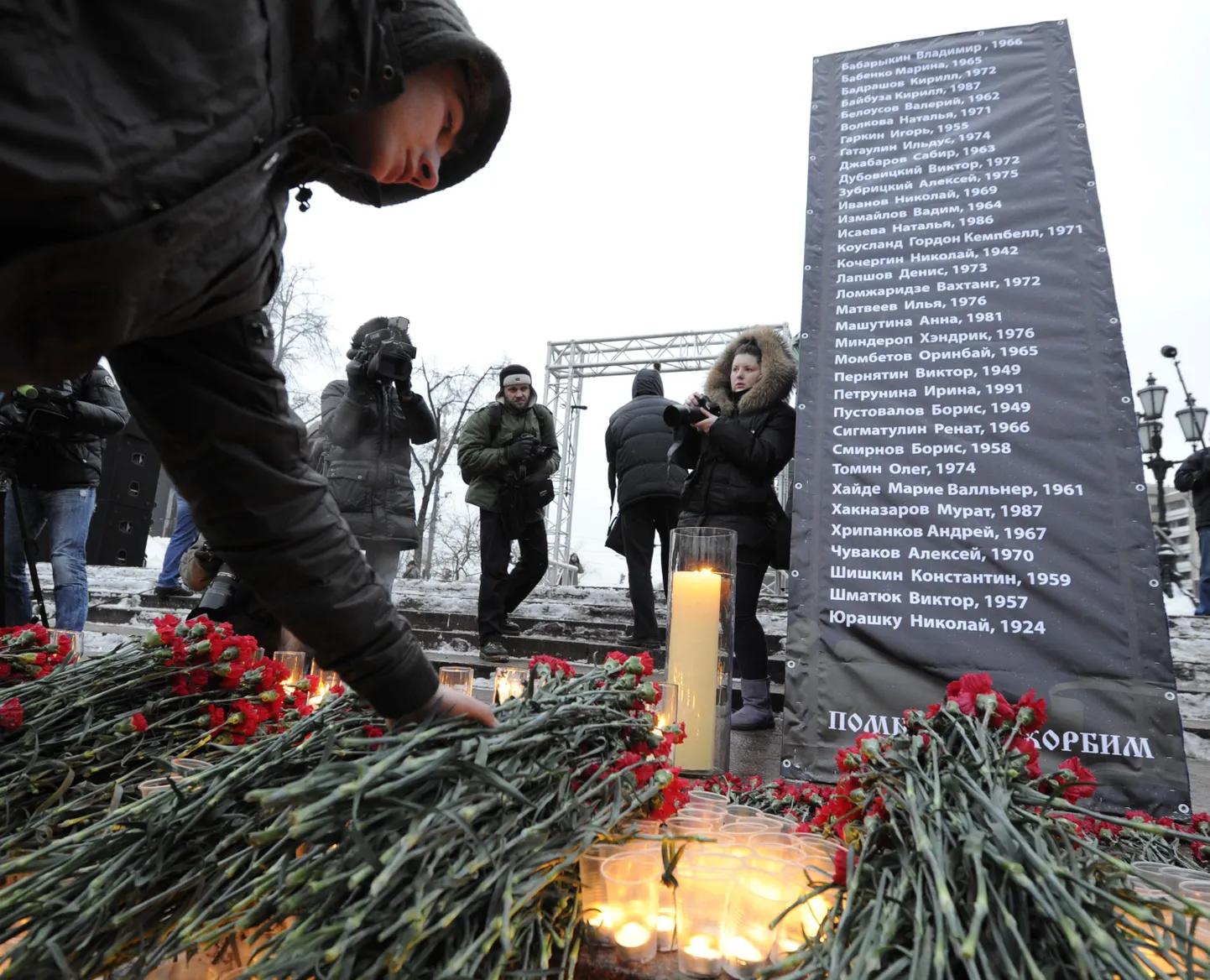 Lilled, küünlad ja tahvel Domodedovo terroriaktis hukkunute nimekirjaga Moskvas Puškini-nimelisel väljakul.