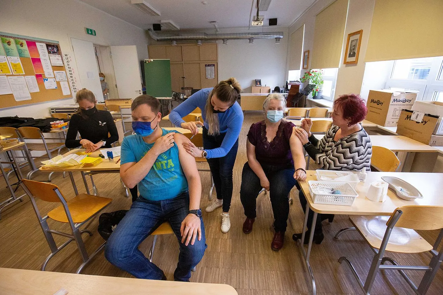 Paide Hammerbecki põhikooli õpetajad Jüri Kaugerand (vasakul) ja Krista Rikk saavad teistkordse vaktsiinisüsti pereõdedelt Ülle Tilgalt (paremal) ja Merit Vaarmalt.