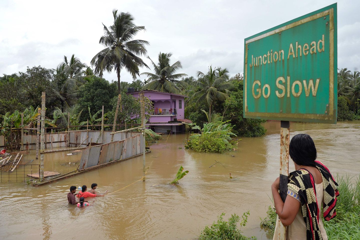 Naine jälgimas kohalikke kahlamas vees Kozhikode piirkonna üleujutatud tänaval Kerala osariigis.
