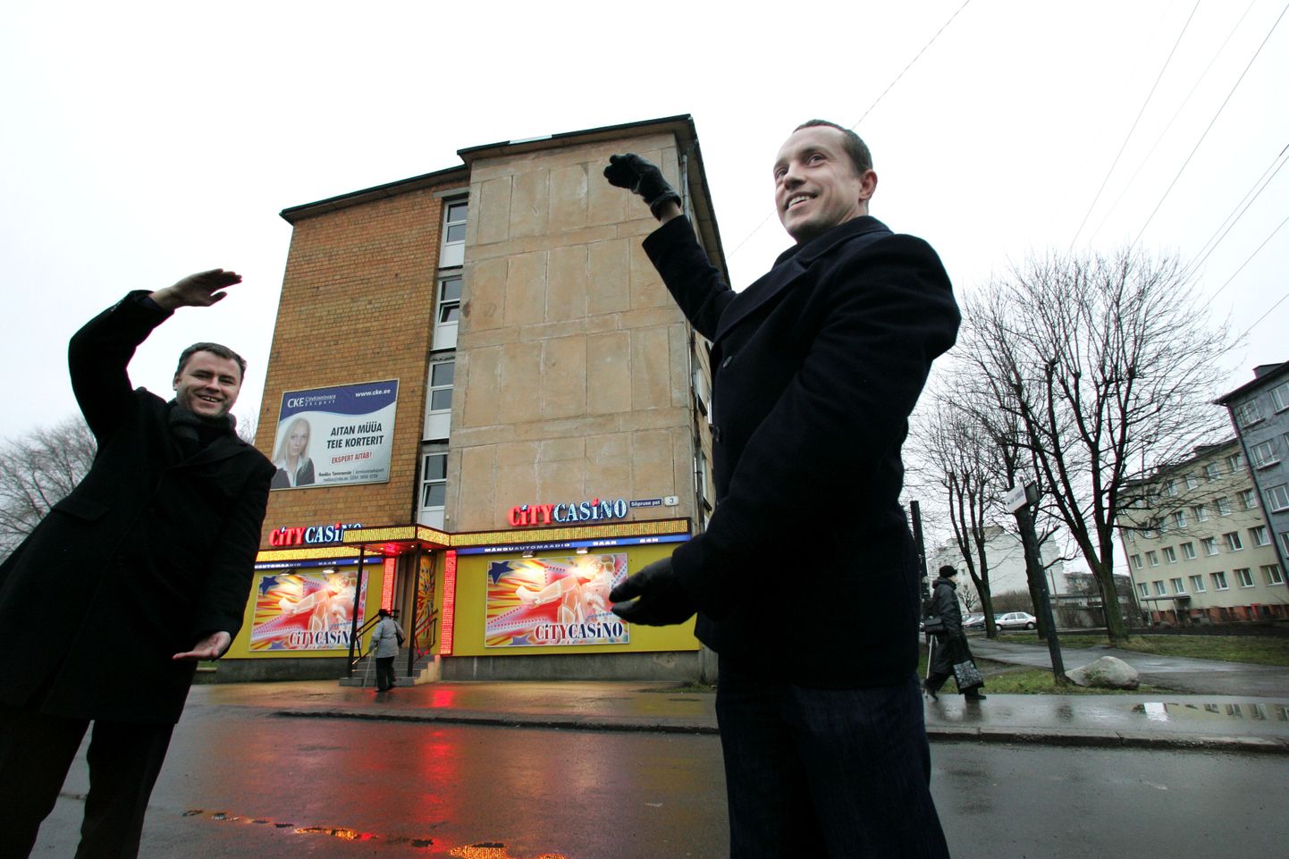 CKE Inkasso juhatuse liikmed Raul Reinsalu (vasakul) ja Priit Pööbo poseerivad Tallinnas paneelmaja ees, mille seinale lubavad nad 5. jaanuariks riputada hiiglasliku plakati võlgnike nimedega.
