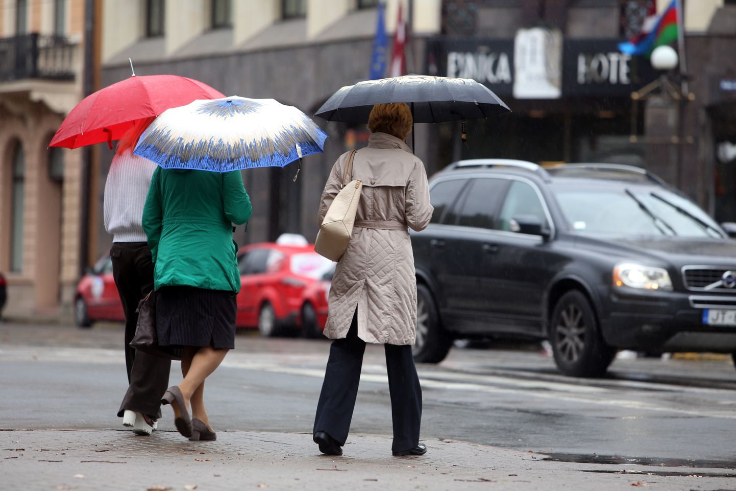 Sievietes ar lietussargiem lietainā dienā.