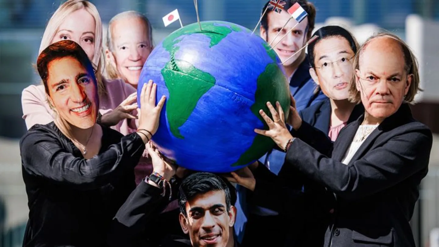 Люди в масках мировых лидеров держат глобус.