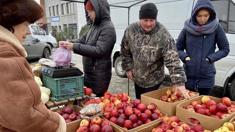 Светлана, Славик и Ольга (справа) продают фрукты в Гостомеле во время затяжного блэкаута 22 декабря. Ольга говорит, что движение и общение с людьми отвлекают ее от холода
