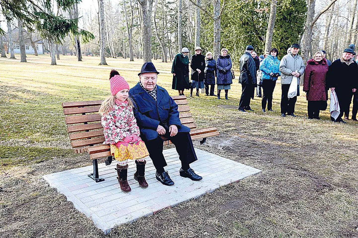Väike Anni Ambos (5, pingil paremal) tõi oma vanavanaisa Kalju Roosve reede pärastlõunal Ülenurme mõisaparki pandud uhiuue pingi juurde.