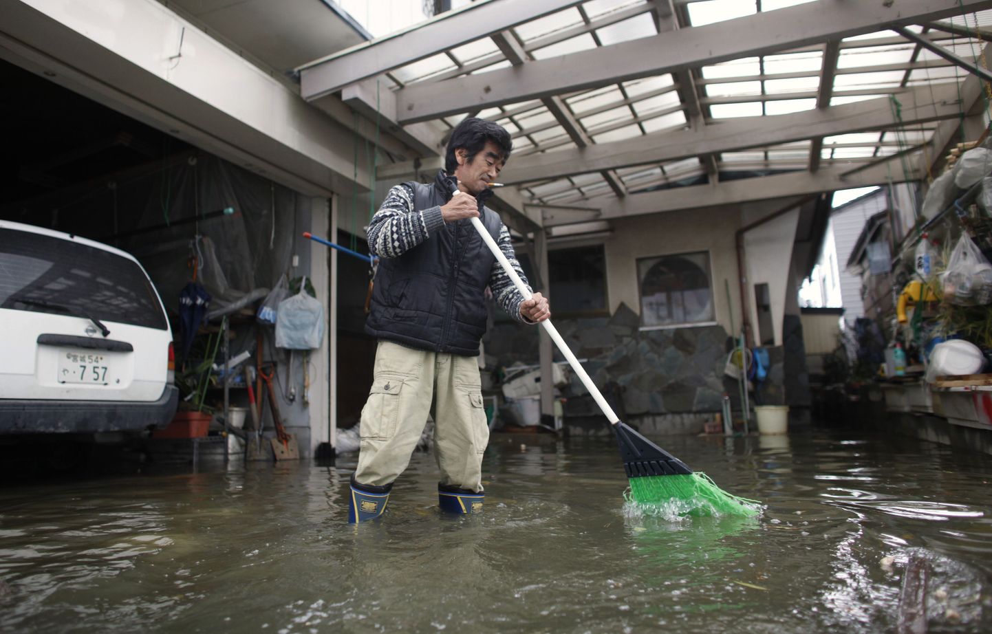Ishinomaki elanik Susumu Miura oma majast vett välja lükkamas