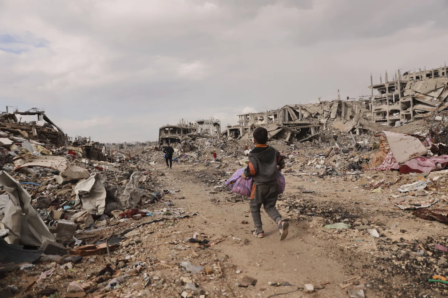 Palestiina poiss kõnnib koos perega Gaza linnas keset Iisraeli ja Hamasi sõja tekitatud rususid.