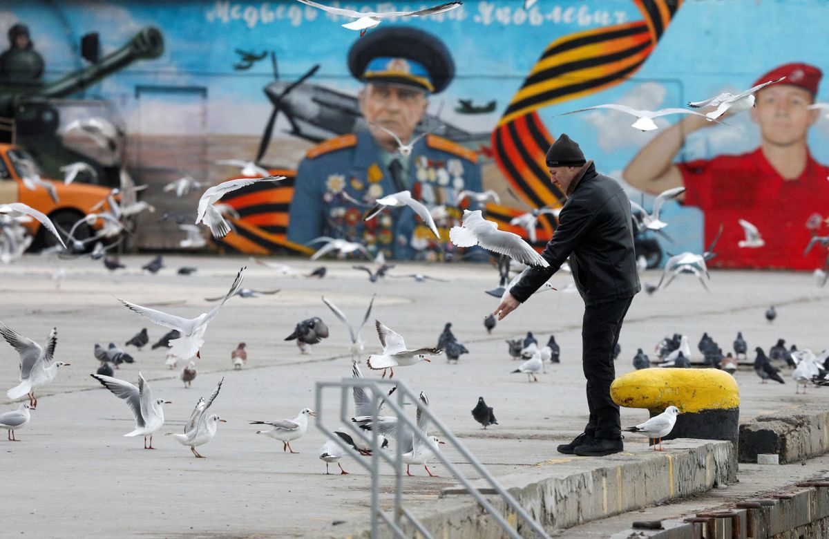 Крымчанин кормит птиц на набережной в Ялте. Ялта десятый год остается оккупированным украинским городом. Крым, 2023 год
