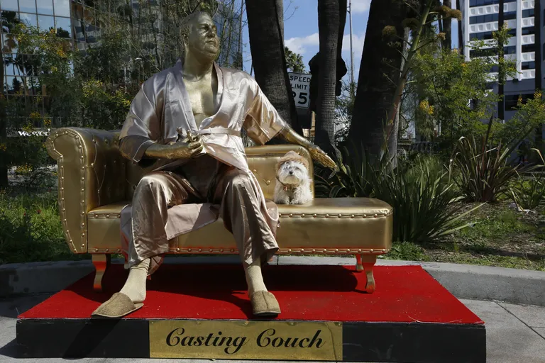 Los Angelese tänavakunstnik Plastic Jesus poseerib kullatud Harvey Weinsteinina viimase «näitlejannavalikukostüümis», hommikumantlis Hollywood Bulevardil.
