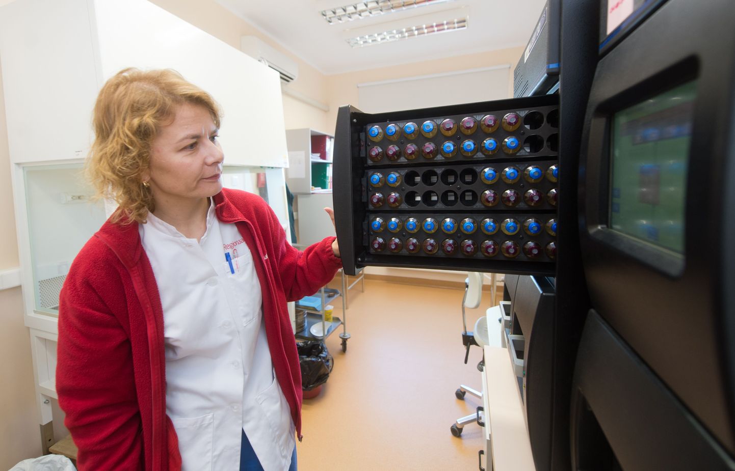 Põhja-Eesti Regionaalhaigla verekeskuse kvaliteedikontrolli osakonna peaspetsialist Aili Kallastu näitab doonoriverd analüüsivaid seadmeid.