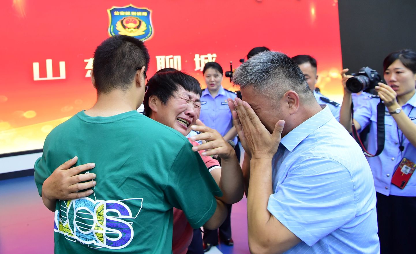 Lapsena röövitud Guo Xinzhen (rohelises särgis) kohtus 24 aasta järel taas oma vanematega.