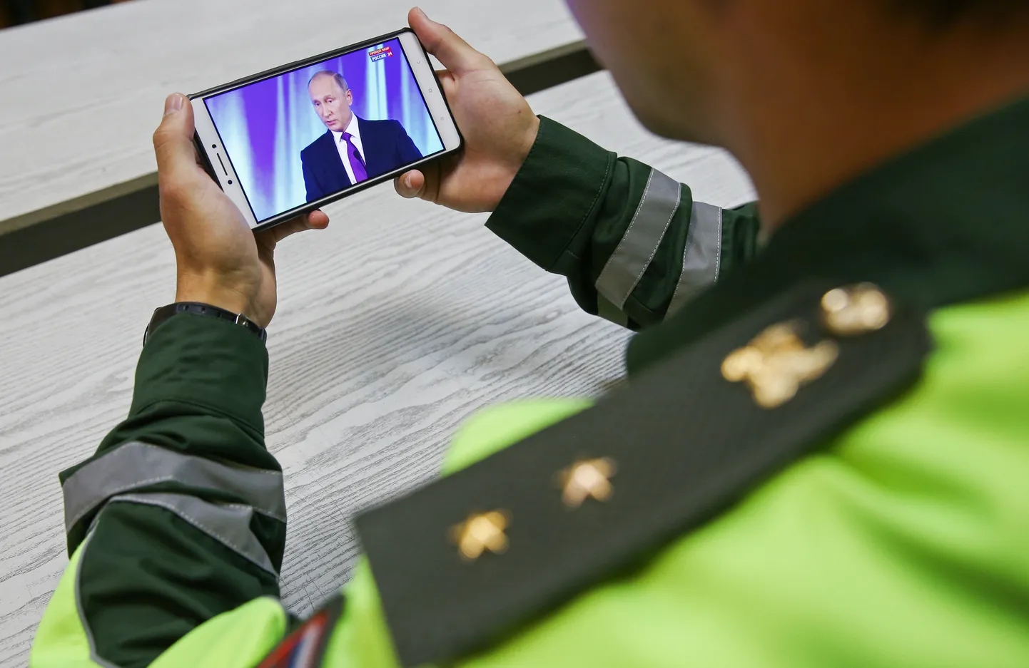Venemaa sõjaväe autoinspektsiooni teenistuja vaatab telefonist ülekannet president Vladimir Putini kõnest Valdai klubi plenaaristungil