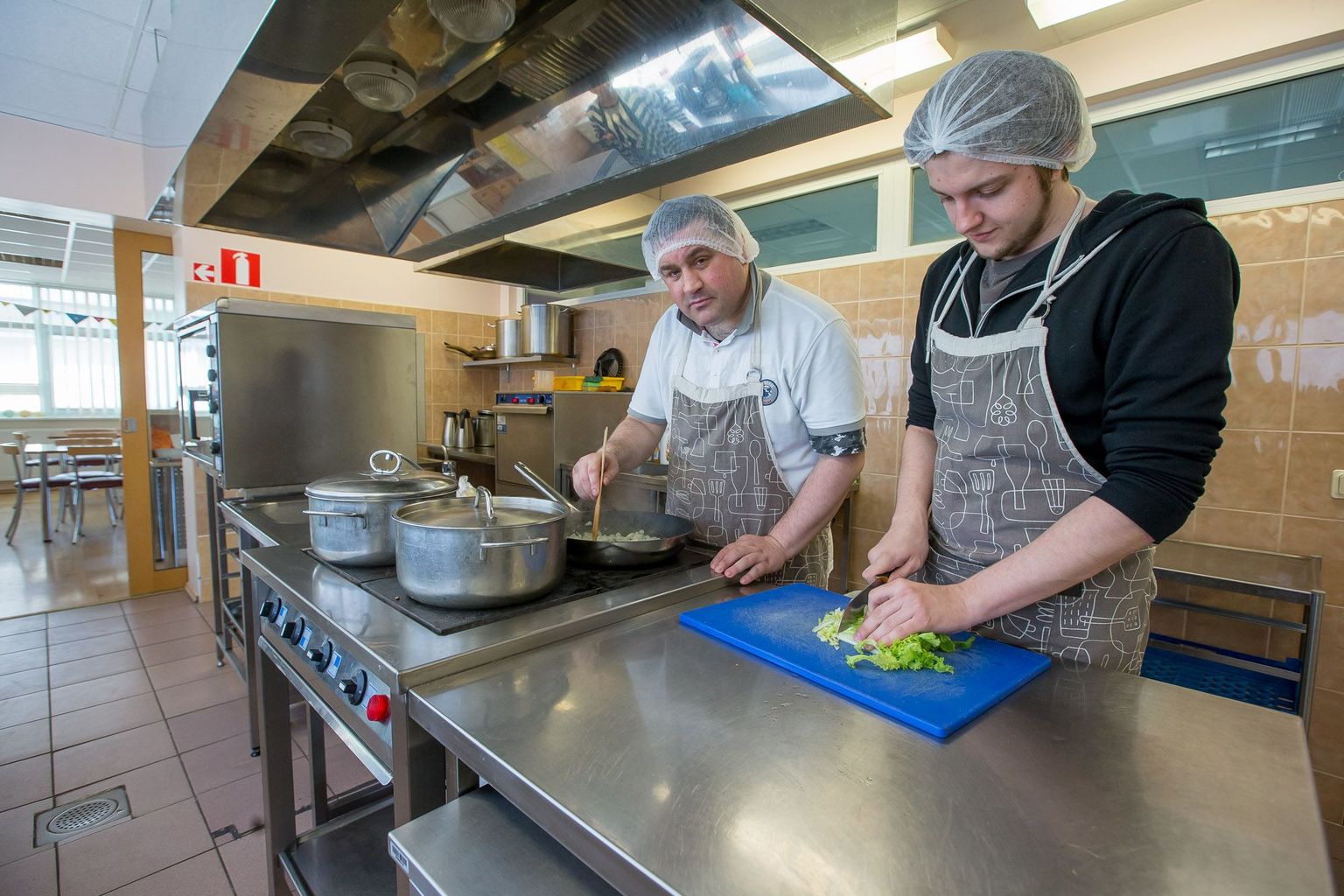 Kaitseväe alternatiivteenistuses olev Madis (paremal) käib Tallinna Vaimse Tervise Keskuse klubimaja köögis abiks Stanislavil, kes omandab seal söögitegemise oskust.