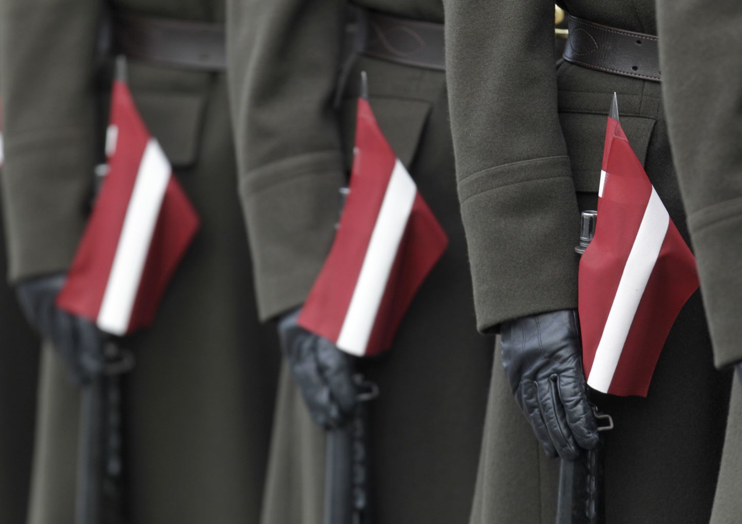 Läti sõdurid lippude ja relvadega riigi iseseisvuspäeva paraadil.