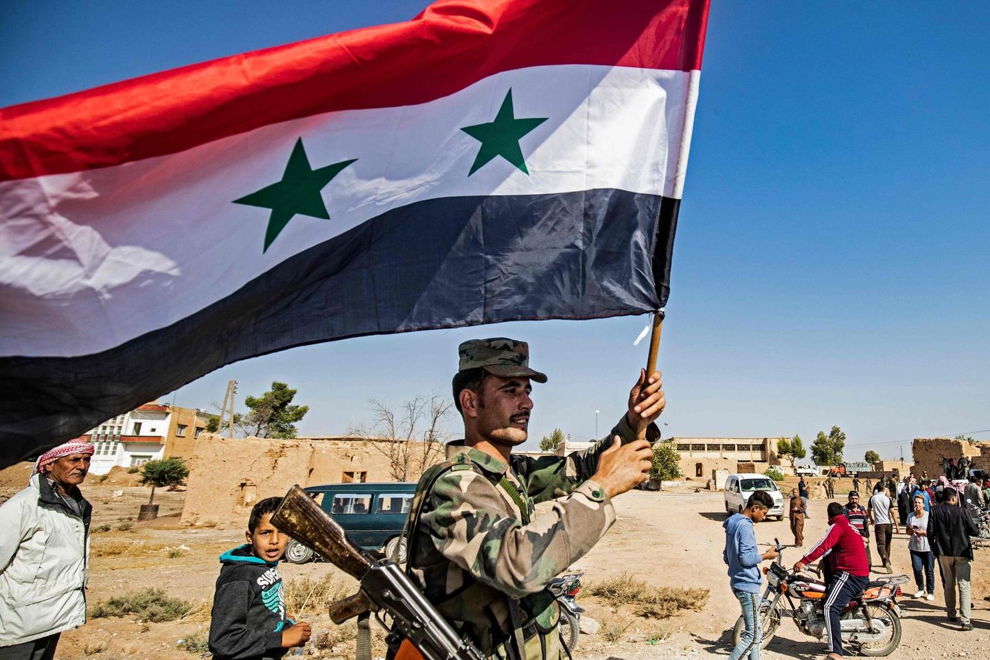 Süüria valitsusvägede sõdur lehvitamas riigi lippu Tall Tamri linna lääneservas paarikümne kilomeetri kaugusel Süüria-Türgi piirist. 