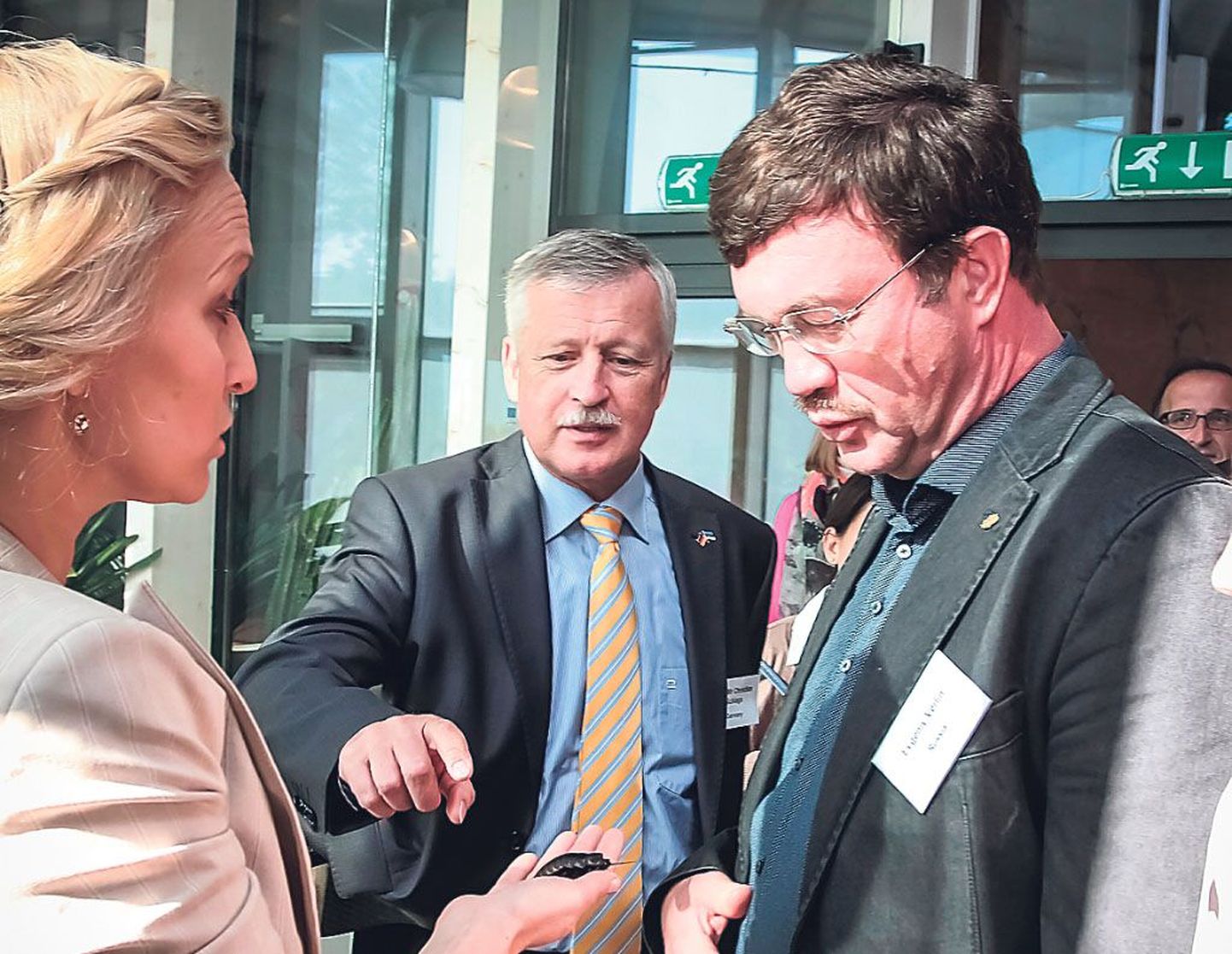Saksamaa suursaadik Christian Schlaga ja Vene saatkonna nõunik Evgeni Verlin (paremal) uurivad prussakat, keda näitab Kristi Raidla.