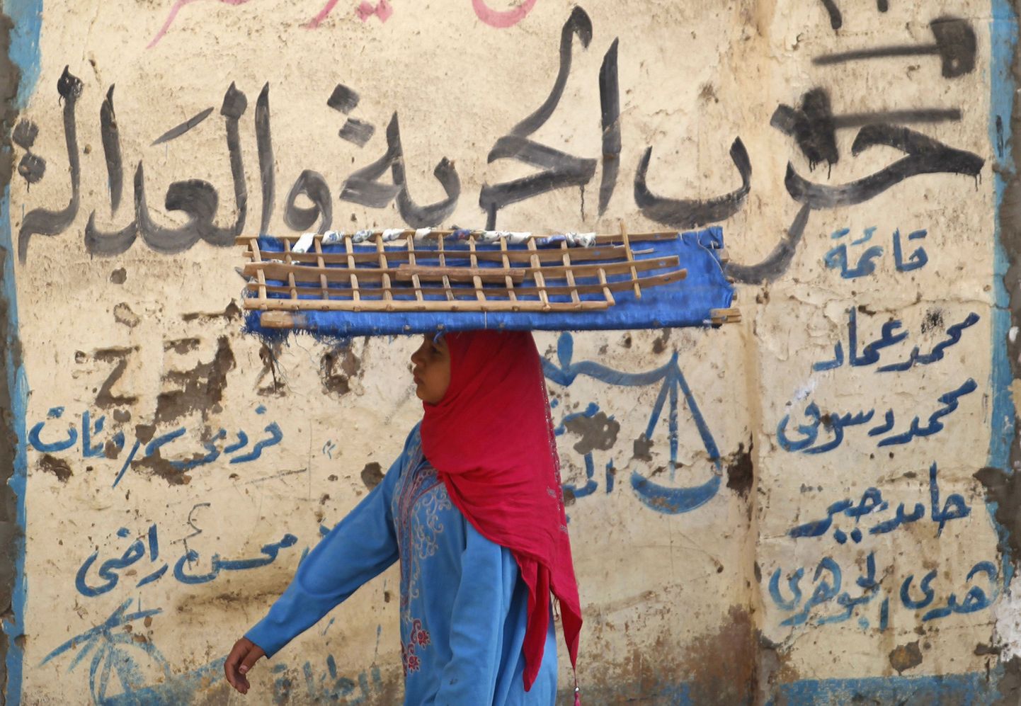 Naine möödub Kairos seinast, millele on maalitud Moslemi Vennaskonna poliitilise käepikenduse Vabaduse ja Õigluse partei nimi.