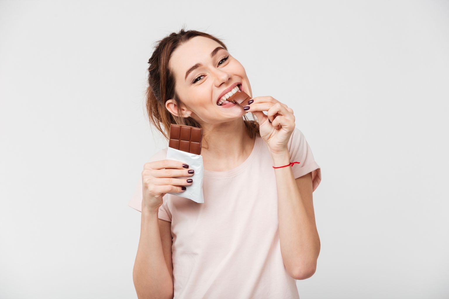 Женщина ест шоколадку. Иллюстративное фото