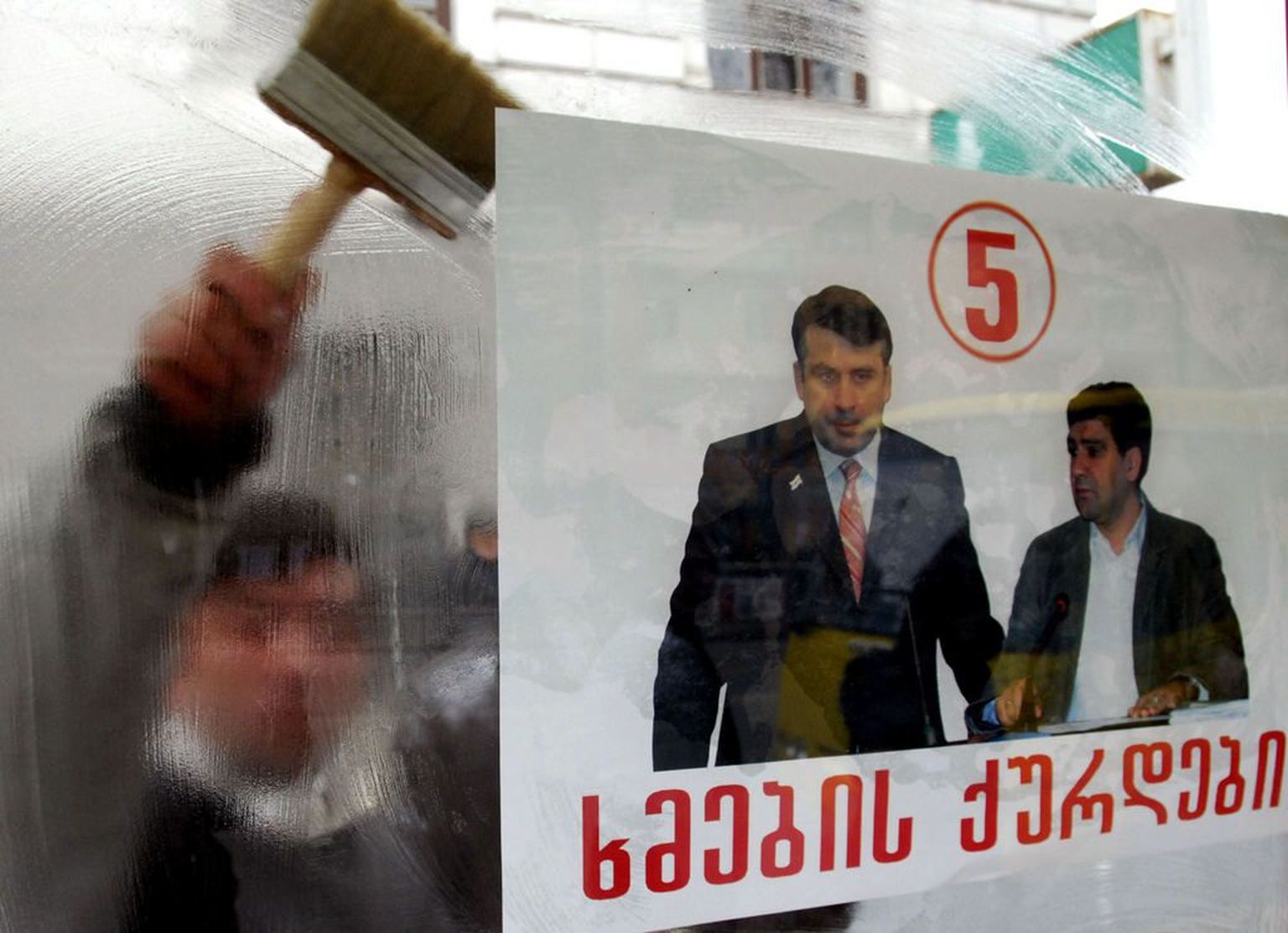 Gruusia opositsionäärid kleepimas akendele president Mikheil Saakašvili vastaseid plakateid..