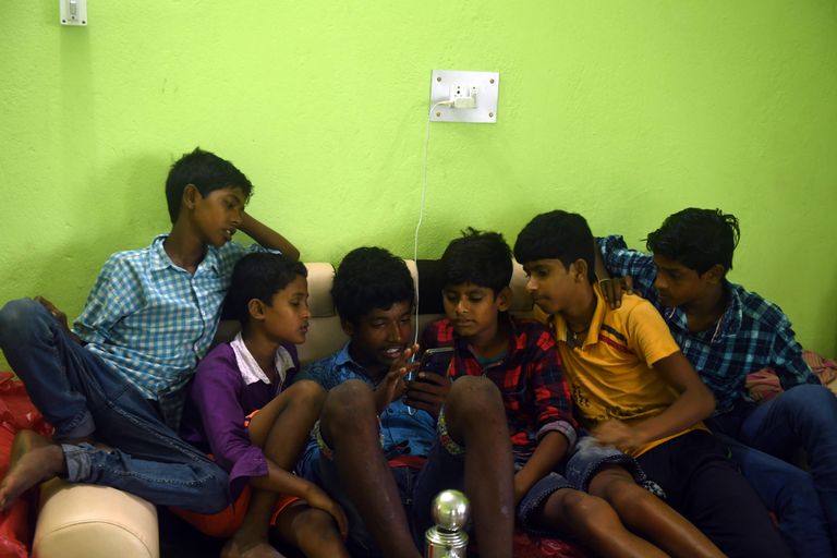 India Lääne-Bengali noored tormivarjendis mobiilimängu mängimas