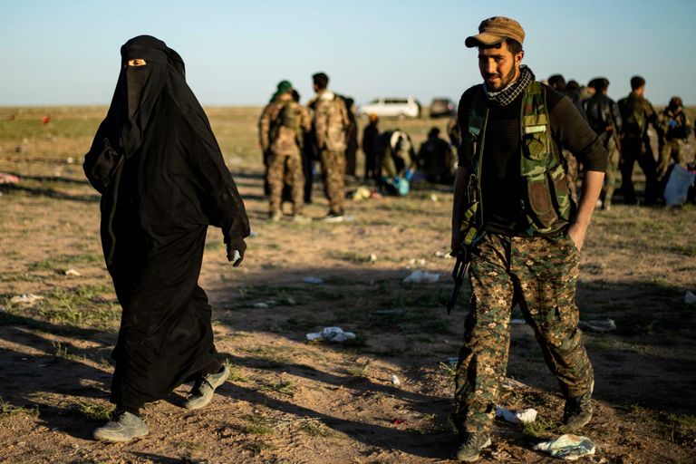 Kurdi võitleja saatmas Baghuzist evakueeritud naist