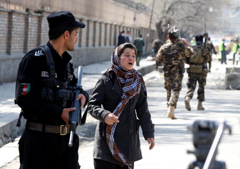 Afganistani naine ja julgeolekutöötaja plahvatuskoha lähistel.