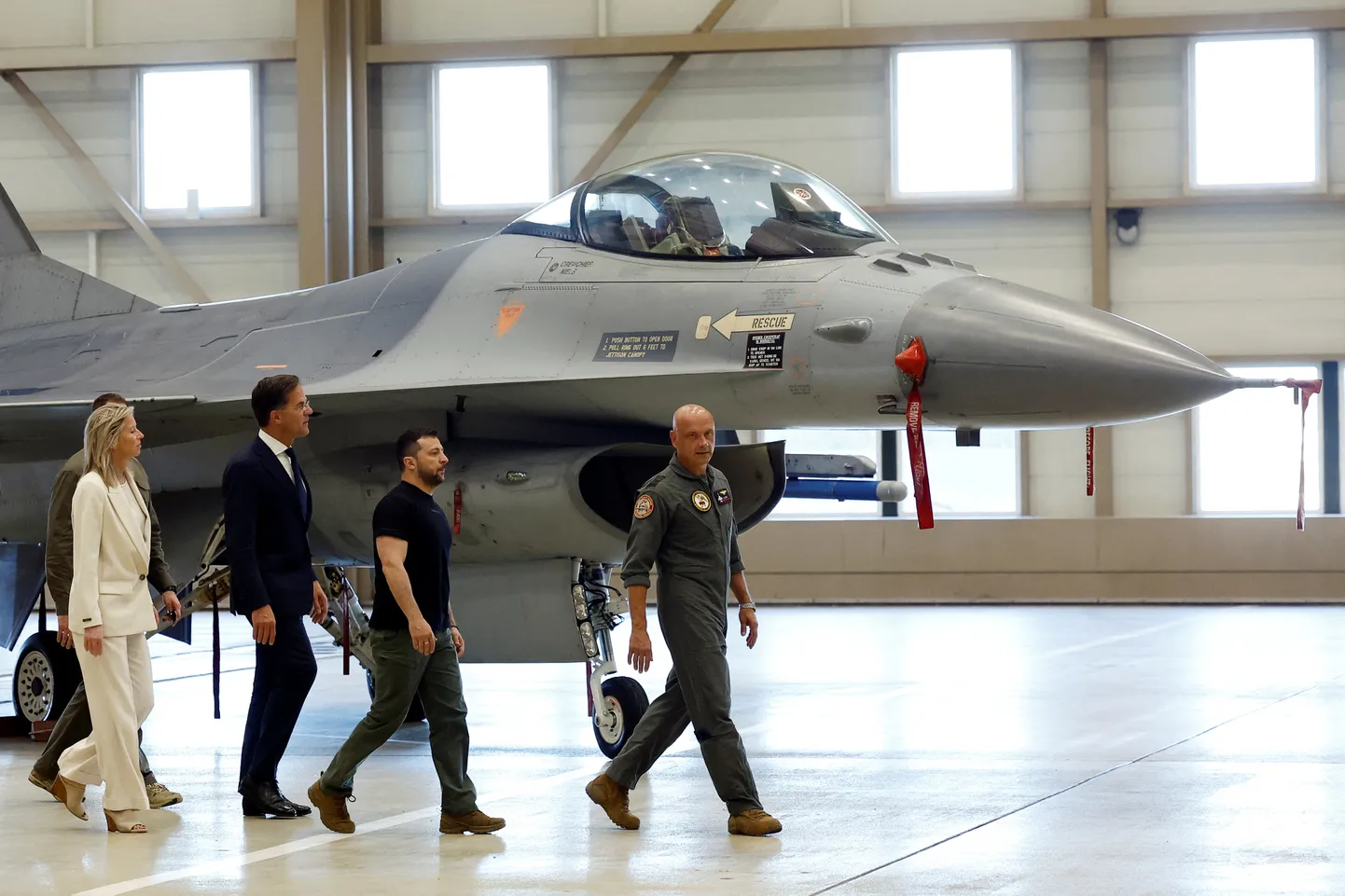 Ukraina president Volodõmõr Zelenskõi ja Hollandi peaminister Mark Rutte kaaskonnaga Eindhoveni õhuväebaasis, taustal hävitaja F-16.