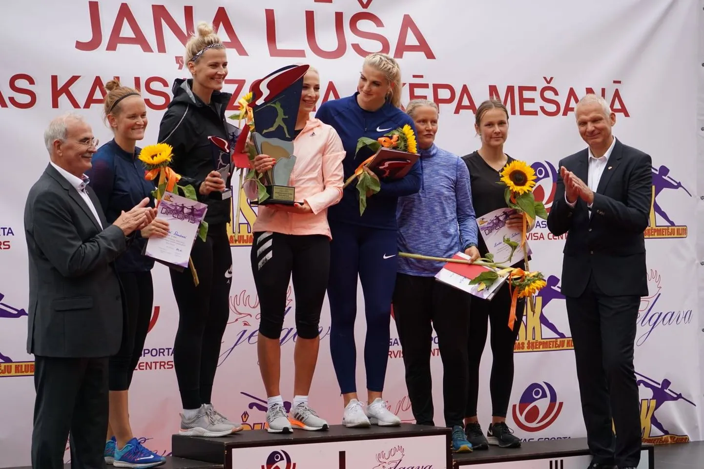 Sacensību laureātes uz goda pjedestāla.