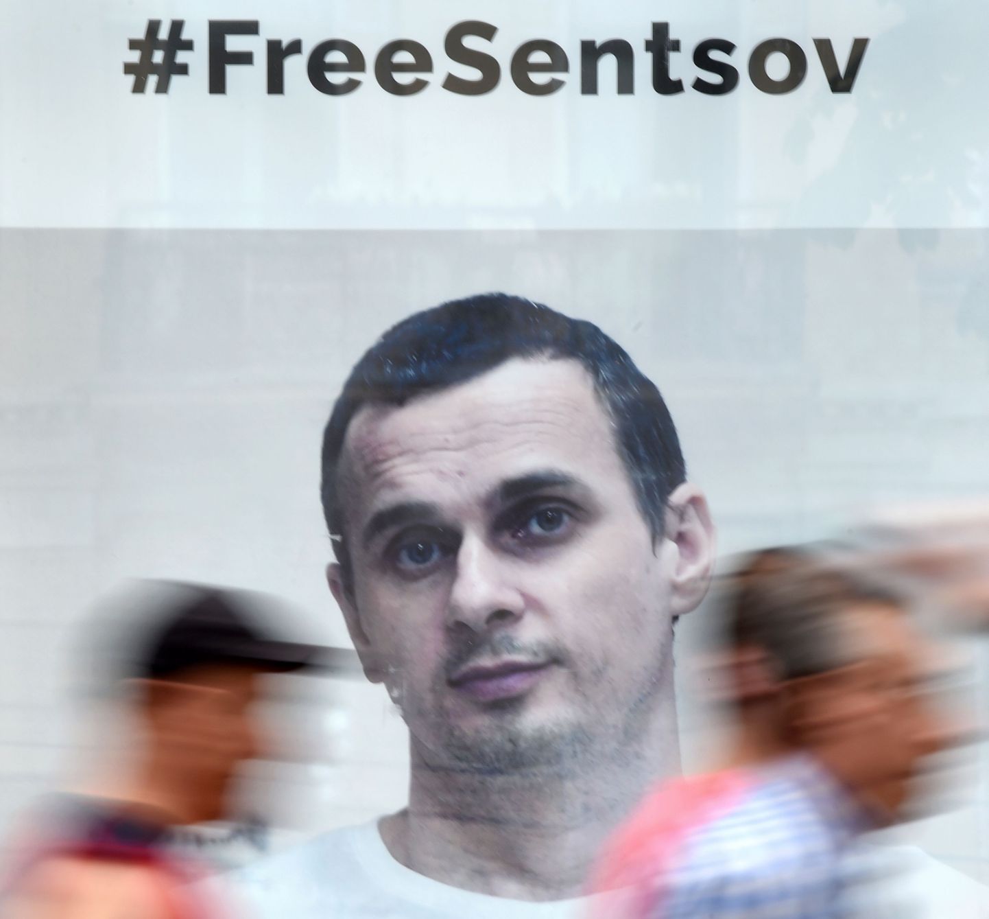 Inimesed jalutavad mööda plakatist, mis kutsub üles Oleg Sentsovi vabastama.