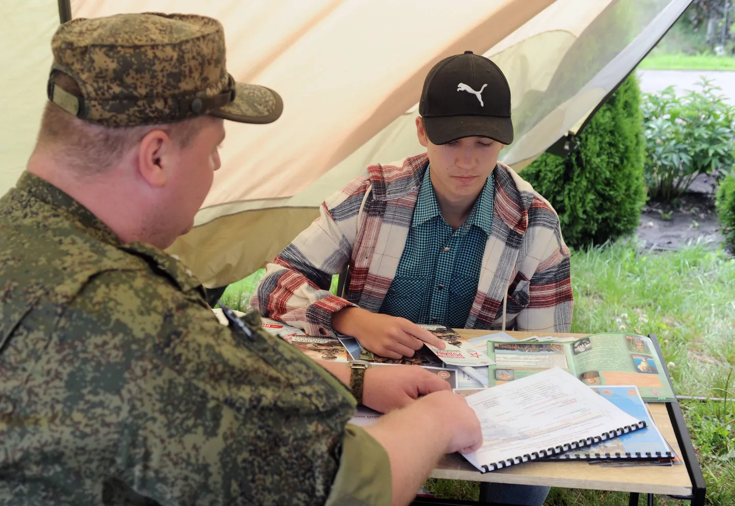 Vene armee instruktor räägib noore mehega mobiilses värbamispunktis, Lääne Venemaal asuvas Tambovi oblastis, 9. juulil 2023. a.
